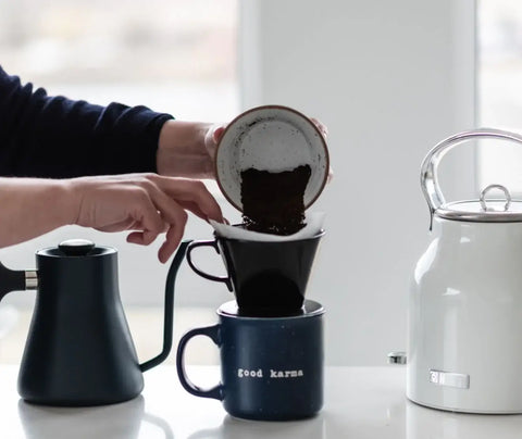 Adding coffee grounds to a pour over coffee maker