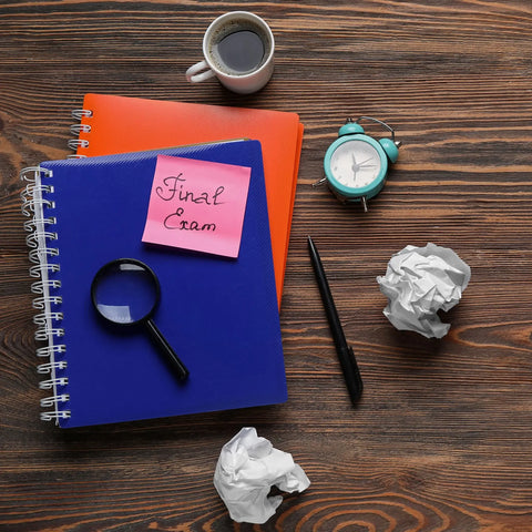 A red and blue spiral notebook on a wooden desk.