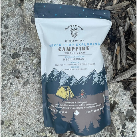A 1lb pack of medium roast Campfire coffee sitting outside on the ground.
