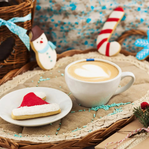 A christmas latte with a santa shaped sugar cookie.