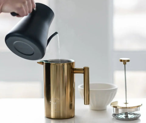 a person preheating a french press to show how to use a french press